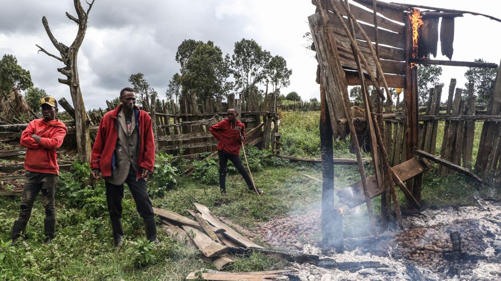 Kenyatta Ngusilo (C), a member of the Ogiek community, watches as his storehouse burns in Sasimwani Mau Forest, 2023. Hundreds of Ogiek people were left homeless after the Kenyan government evicted alleged encroachers.