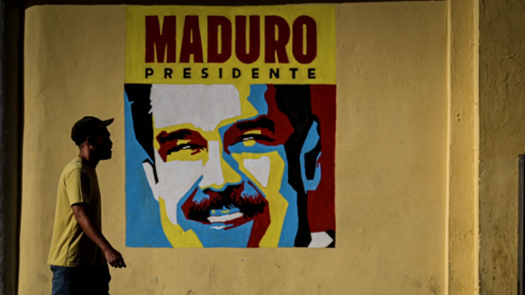 walking past poster of Maduro