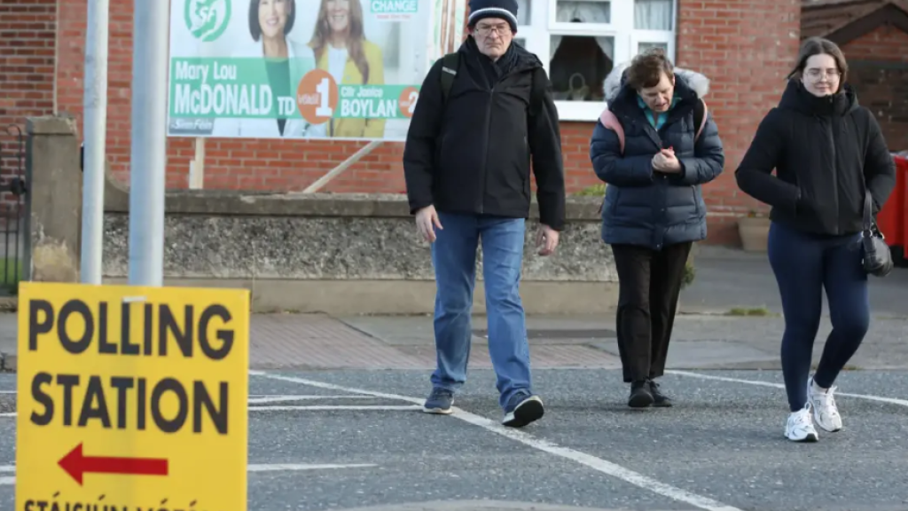 People walk past a polling station sign in Cabra, Dublin, ahead of Ireland’s general election on Friday. 