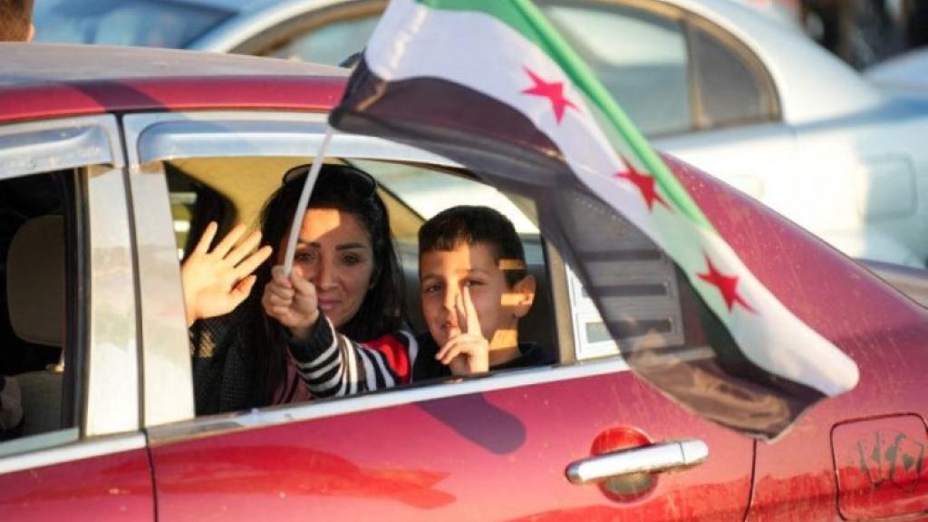 A Syrian family celebrates the fall of the regime in Umayyad Square in Damascus