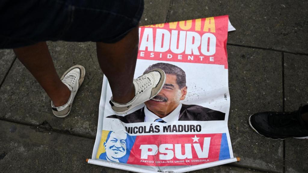 An opponent of Venezuelan President Nicolás Maduro’s government steps on an election campaign poster with the image of Maduro during a protest at the Petare neighborhood in Caracas on July 29, 2024, a day after the Venezuelan presidential election.