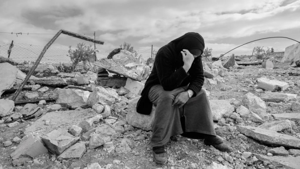 A Palestinian woman sits on the ruins of her house that was destroyed by the Israeli military in Masafer Yatta, January 2023. Photo from Wikimedia Commons.