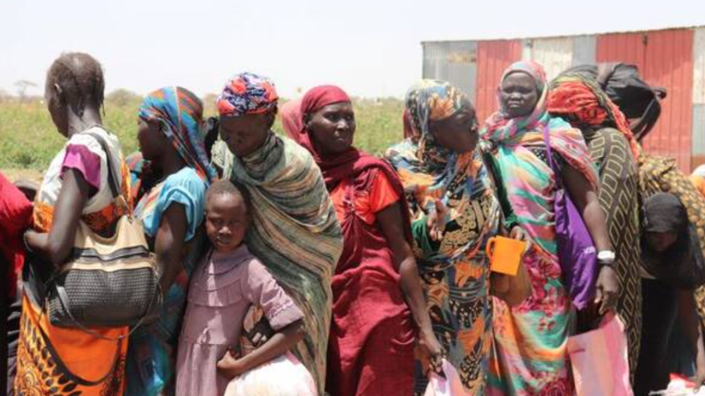 South Sudanese people queue to get on board a boat after fleeing fighting in Sudan, 8 May 2024.