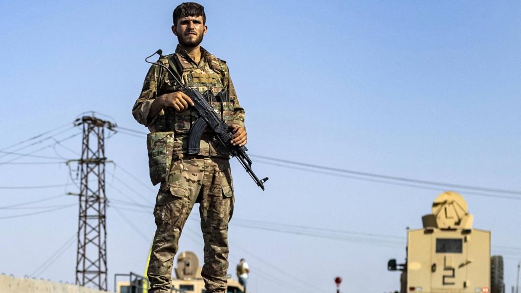 A Syrian Democratic Forces member stands guard along a road in town of al-Busayrah in Syria's Deir Ezzor province, on 4 September 2023