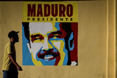 walking past poster of Maduro