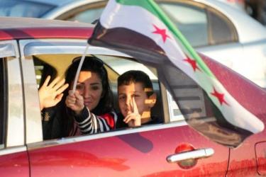 A Syrian family celebrates the fall of the regime in Umayyad Square in Damascus
