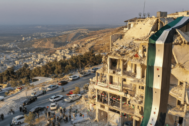 Free Syria flag drapped over ruins