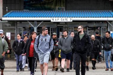 Workers leave the Stellantis Windsor Assembly Plant, in Windsor, Ont., ahead of a shutdown linked to US auto tariffs.