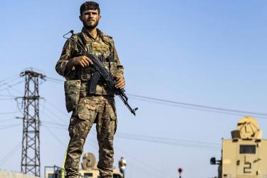 A Syrian Democratic Forces member stands guard along a road in town of al-Busayrah in Syria's Deir Ezzor province, on 4 September 2023