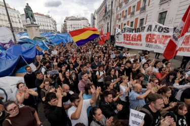 Demonstrators protesting Spain's housing and rental crisis, on Madrid's Puerta del Sol with the protest encampment visible in the background (2 October 2026)
