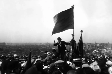 Discours de Jaurès sous un drapeau rouge au Pré-Saint-Gervais, lors de la manifestation contre la loi des Trois ans, 25 mai 1913. © Maurice-Louis Branger / Domaine public.